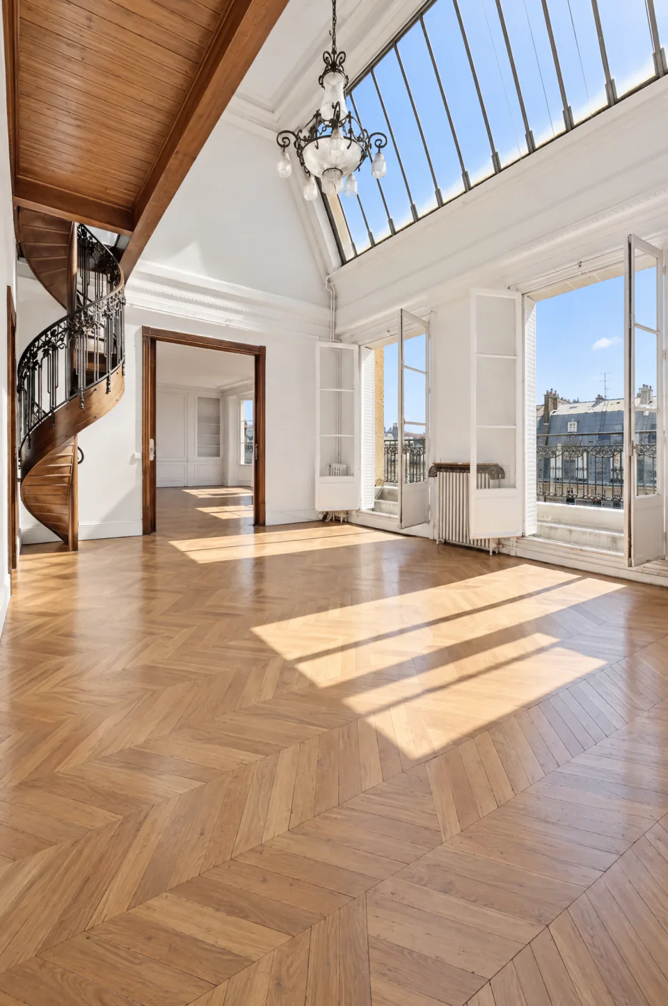 Séjour double hauteur sous verrière avec parquet en point de Hongrie et escalier en colimaçon